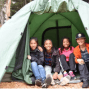 A family camping inside a tent.