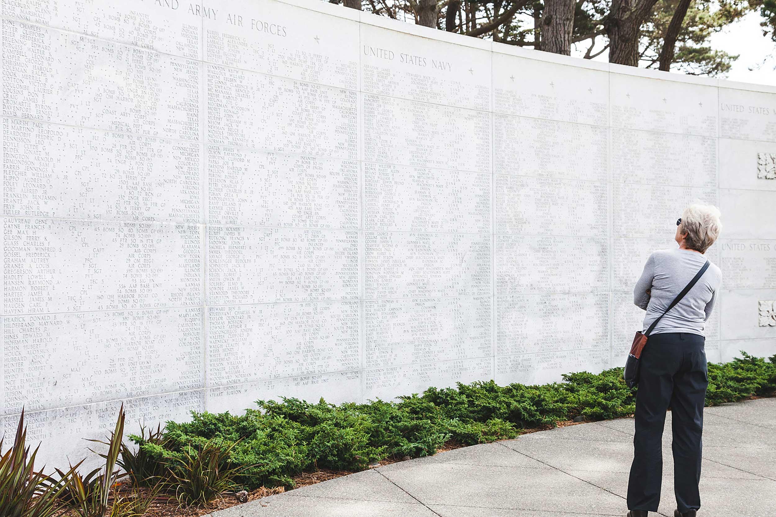 Woman reading names inscribed on the World War II West Coast Memorial to the Missing in the Presidio.