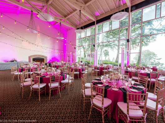 Image of an indoor venue set for a party with pink accent lights.
